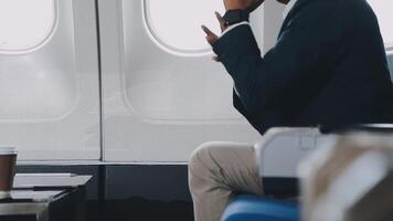 Side view portrait of handsome bearded businessman working while enjoying flight in first class, copy space video