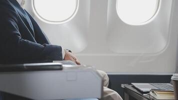 Side view portrait of handsome bearded businessman working while enjoying flight in first class, copy space video