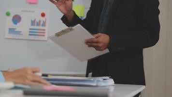 conferencia de trabajo conjunto, reunión del equipo de negocios presente, colegas inversores que discuten los datos del gráfico financiero del nuevo plan en la mesa de la oficina con computadora portátil y tableta digital, finanzas, contabilidad, inversión. video