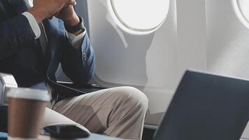 Side view portrait of handsome bearded businessman working while enjoying flight in first class, copy space video