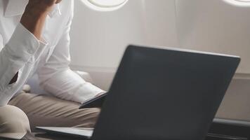 Side view portrait of handsome bearded businessman working while enjoying flight in first class, copy space video