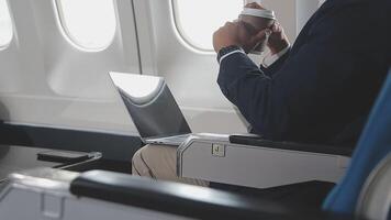 Side view portrait of handsome bearded businessman working while enjoying flight in first class, copy space video