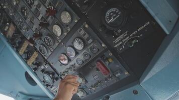 The pilot presses the power buttons on the control panel to control the aircraft in front of cockpit windshield video