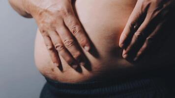 hombre señalando propio insalubre grande barriga con visceral o subcutáneo grasas actitud salud riesgo. video