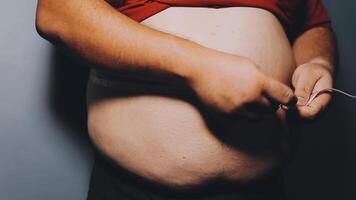 Man pointing own unhealthy big belly with visceral or subcutaneous fats. Pose health risk. video