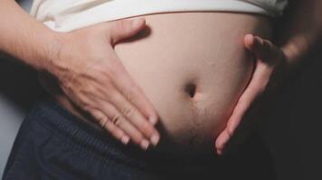 hombre señalando propio insalubre grande barriga con visceral o subcutáneo grasas actitud salud riesgo. video