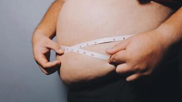 Man pointing own unhealthy big belly with visceral or subcutaneous fats. Pose health risk. video