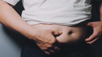 homem apontando próprio pouco saudável grande barriga com visceral ou subcutâneo gorduras. pose saúde risco. video