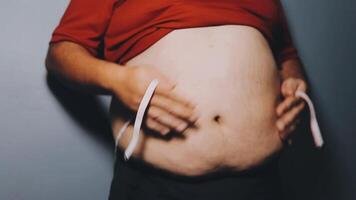 hombre señalando propio insalubre grande barriga con visceral o subcutáneo grasas actitud salud riesgo. video