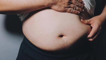 homem apontando próprio pouco saudável grande barriga com visceral ou subcutâneo gorduras. pose saúde risco. video