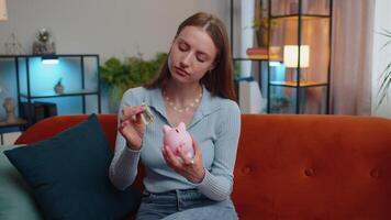 Poor young woman holding piggybank and one dollar banknote, financial crisis, bankruptcy, poverty video