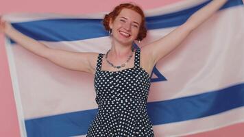 Happy young woman in dress waving and wrapping in Israel national flag, celebrating Independence day video