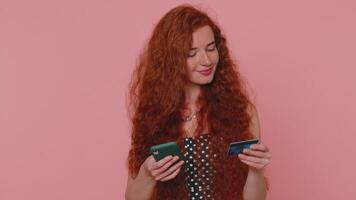 Redhead girl use credit bank card and smartphone while transferring money purchases online shopping video