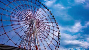 A timelapse of ferris wheel at the amusement park in Odaiba Tokyo daytime medium shot panning video