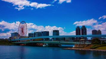 A timelapse of ferris wheel at the amusement park in Odaiba Tokyo daytime wide shot tilt video
