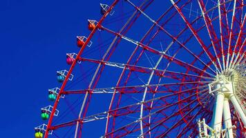 A timelapse of ferris wheel at the amusement park in Odaiba Tokyo daytime long shot panning video