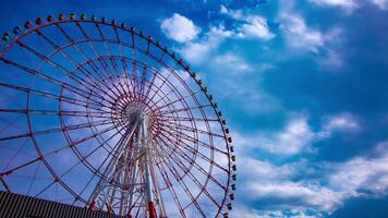 A timelapse of ferris wheel at the amusement park in Odaiba Tokyo daytime medium shot tilt video