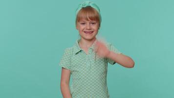 gelukkig kleuter kinderen meisje glimlachen vriendelijk Bij camera en golvend handen gebaren Hallo of Vaarwel video
