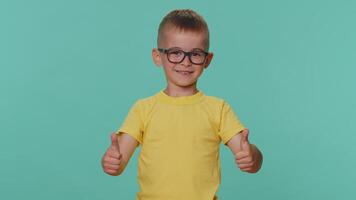 Lycklig litet barn barn pojke höjer tummen upp håller med med något eller ger positiv svar, tycka om Bra video