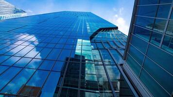 un lapso de tiempo de el nube reflejando el espejo de el edificio en tokio amplio Disparo panorámica video