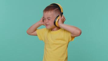 Lycklig liten litet barn barn pojke lyssnande musik via hörlurar, dans disko, lura, har roligt video