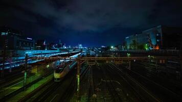 A timelapse of the train at Ueno station at night long exposure wide shot tilt video