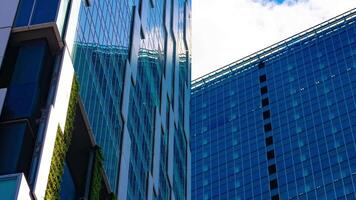 A timelapse of the cloud reflecting the mirror of the building in Tokyo panning video