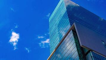 A timelapse of the cloud reflecting the mirror of the building in Tokyo panning video