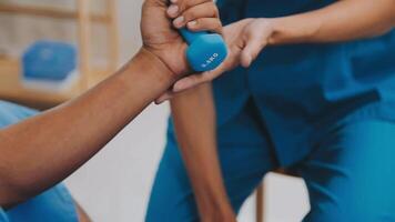 Doctor or Physiotherapist working examining treating injured arm of athlete male patient, stretching and exercise, Doing the Rehabilitation therapy pain in clinic. video