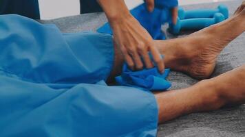 Patient at the physiotherapy doing physical exercises with his therapist video