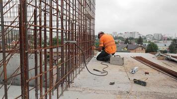 a soldador em a construção local soldas a metal estruturas do a monolítico Fundação do a casa. video