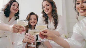 meninas beber champanhe em seus Casamento dia. festivo manhã do a noiva com dela amigos. derramando champanhe e uma feliz humor. video