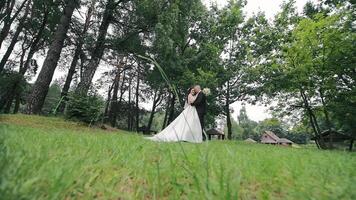 The bride and groom embrace in the park. A young couple enjoys a hug in a beautiful park. Wedding day of the bride and groom video