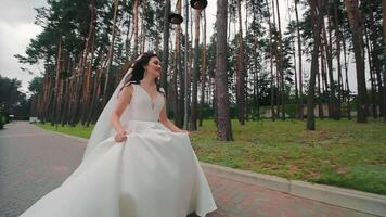 de bruid loopt alleen in de park Aan haar bruiloft dag. video