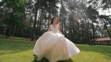 Happy bride jogging in the park and smiling at the camera. Wedding walk of the bride in the park video