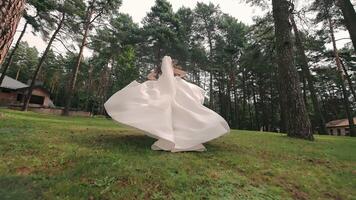 de brud i en Snövit klänning är löpning i de parkera. fantastisk fly av de brud från de bröllop. bak- se. video