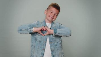 Smiling toddler boy makes heart gesture demonstrates love sign expresses good feelings and sympathy video