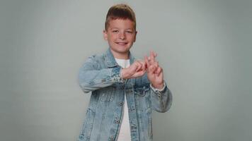 vrolijk kind jongen tonen hekje symbool met handen, houdt getagd bericht, populair virale inhoud video