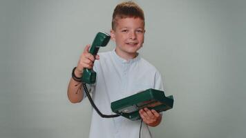 portrait de bambin enfant garçon parlant sur câblé ancien Téléphone de années 80, dit Hey vous appel moi retour video