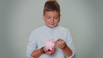 Poor boy upset over insufficient amount of money, holding piggybank, one dollar banknote bankruptcy video