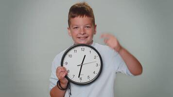 Toddler kid boy showing time on wall office clock, ok, thumb up, approve, pointing finger at camera video