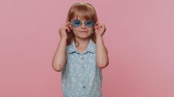 Child girl kid wearing pink sunglasses, charming smile, showing thumbs up like, positive feedback video