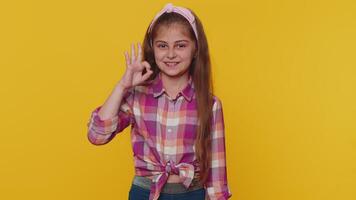 Happy cheerful child girl kid looking approvingly at camera showing ok gesture, positive like sign video
