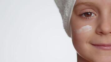 bonito joven niño niña aplicando limpieza hidratante cara crema, protección de la piel natural crema productos cosméticos video