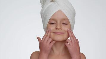 Pretty young child girl applying cleansing moisturizing face cream, skincare natural creme cosmetics video