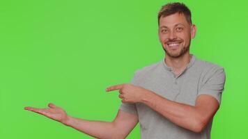 Man guy showing thumbs up and pointing left empty place, advertising area for commercial text, logo video