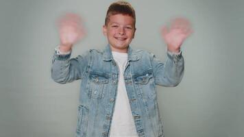 Toddler boy smiling friendly at camera and waving hands gesturing hello or goodbye, welcoming video