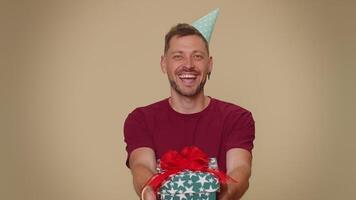 Handsome man presenting birthday gift box, offer wrapped present career bonus, celebrating party video