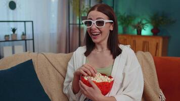 donna seduta su divano mangiare Popcorn e Guardando interessante tv seriale, sport gioco in linea a casa video