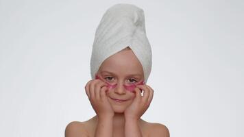 sorridente criança menina aplicando Rosa remendos debaixo olhos, adolescente natural pele Cuidado, perfeito fresco limpar \ limpo video